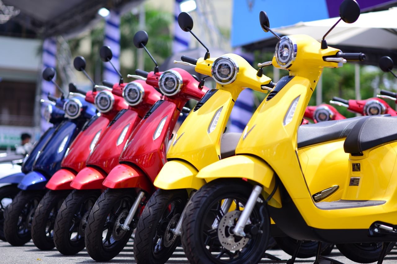 services-03 Vibrant yellow, red, and blue scooters aligned, reflecting urban lifestyle and mobility.